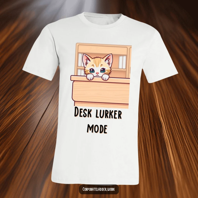 Funny kitten peeking over the edge of a big desk, printed on a t-shirt, conveying curiosity and lighthearted humor.